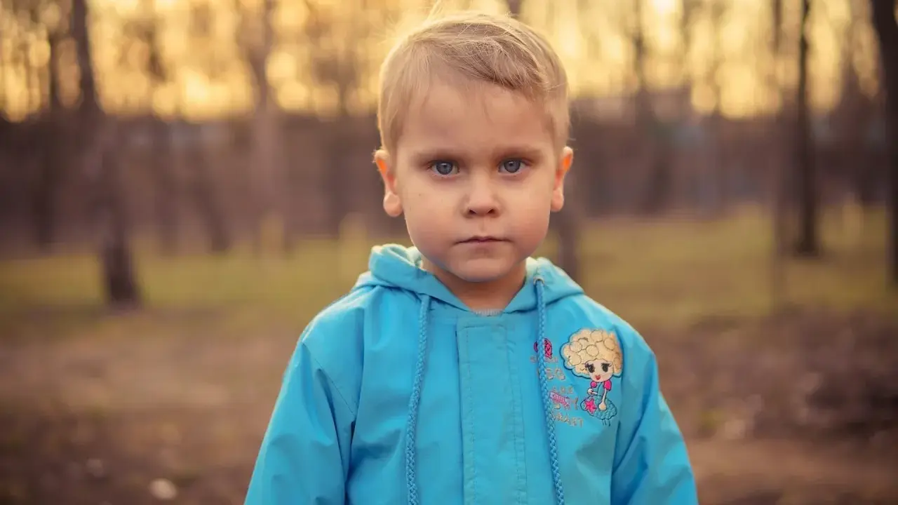 Niño con ojos azules, herencia de su padre ojos azules, y seguro heredará los ojos marrones de su madre.