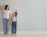 Madre e hija miden su altura. La estatura se hereda del padre o madre, y esta niña parece estar heredando la de su madre.
