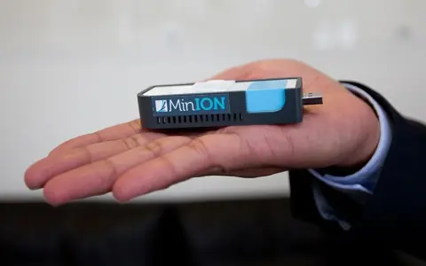 MinION nanopore, un dispositivo portátil de secuenciación genética, descansa en una mano.