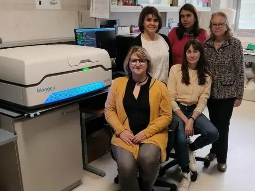 Equipo de científicas posa junto a un equipo de optical genome mapping, listo para desentrañar secretos genéticos.