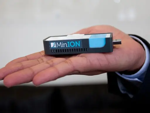 MinION nanopore, un dispositivo portátil de secuenciación genética, descansa en una mano.