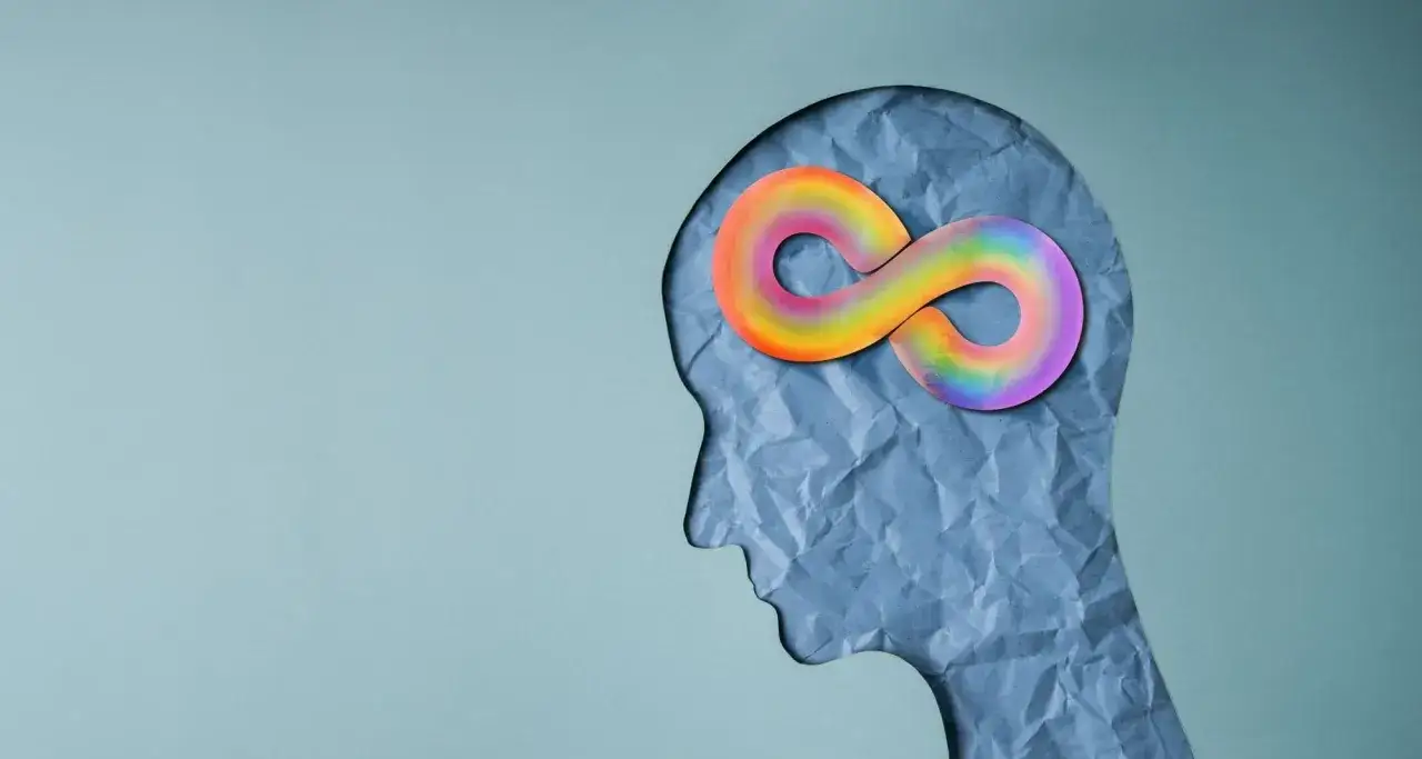 Silueta de cabeza con símbolo del infinito arcoíris en el cerebro. El autismo es genético, una parte intrínseca de la neurodiversidad.
