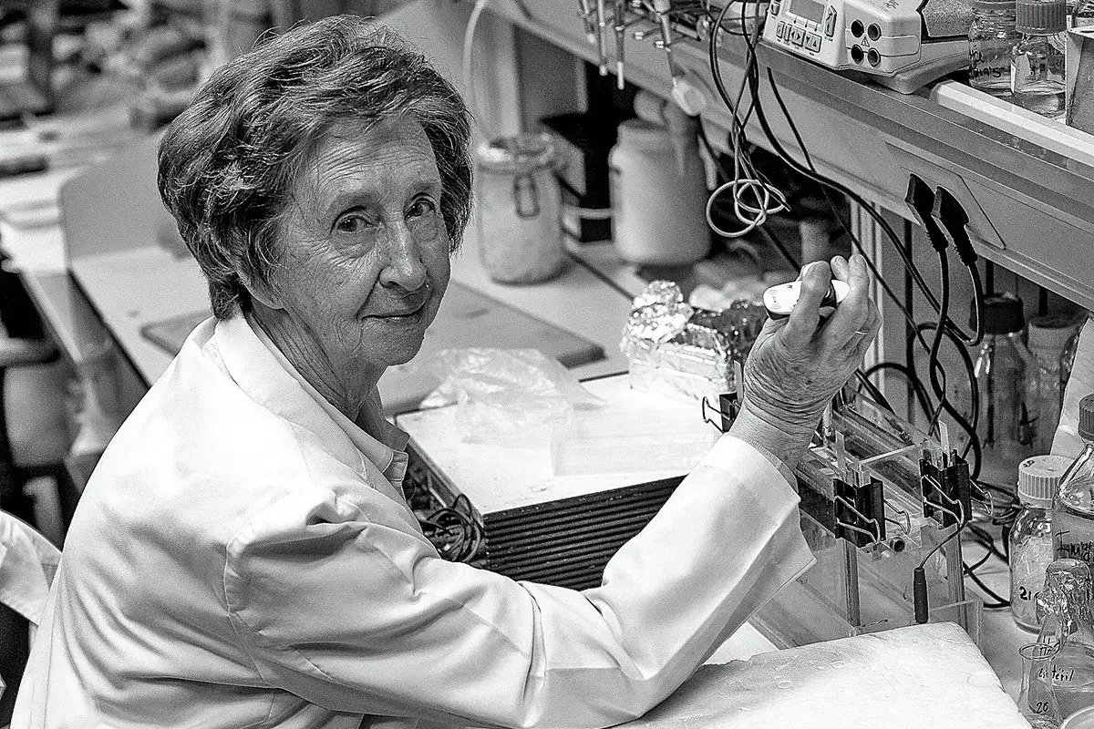 Científica en laboratorio, rodeada de equipos, trabajando en sus descubrimientos. Margarita Salas, pionera en la investigación.